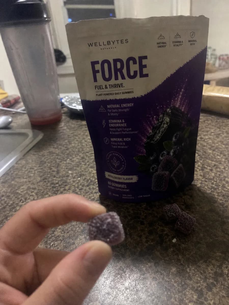 Grainy iPhone-style photo of a WellBytes Force pouch on a kitchen counter with gummies
